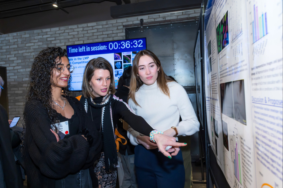 A group of people pointing at a poster